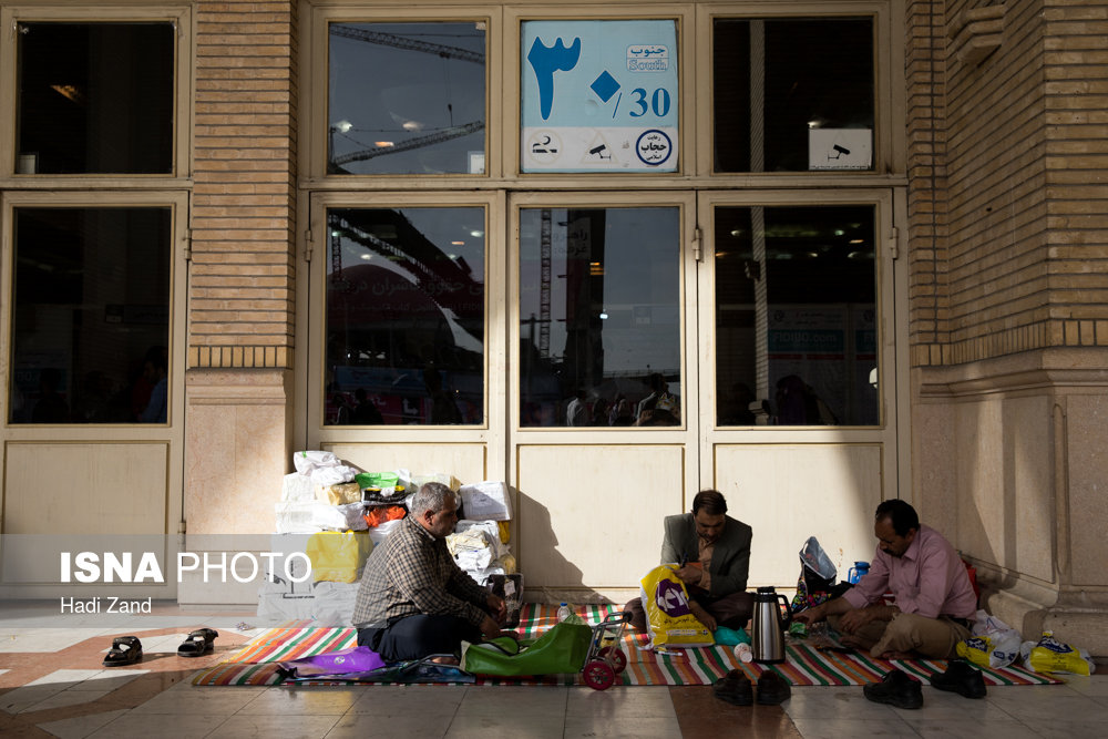 تعدادی از بازدیدکنندگان ششمین روز سی و یکمین نمایشگاه بین المللی کتاب تهران، بعد از خرید کتابهایشان، در گوشه ای از نمایشگاه در حال استراحت هستند
