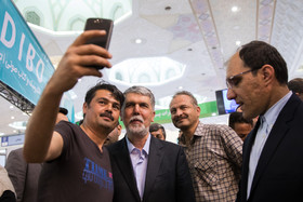 در حاشیه ششمین روز سی و یکمین نمایشگاه بین المللی کتاب تهران، یکی از بازدیدکنندگان از وزیر ارشاد درخواست عکس سلفی میکند و با وی عکس می‌اندازد.