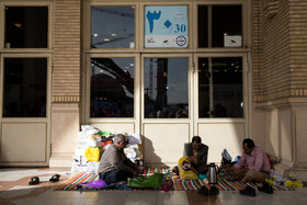 تعدادی از بازدیدکنندگان ششمین روز سی و یکمین نمایشگاه بین المللی کتاب تهران، بعد از خرید کتابهایشان، در گوشه ای از نمایشگاه در حال استراحت هستند