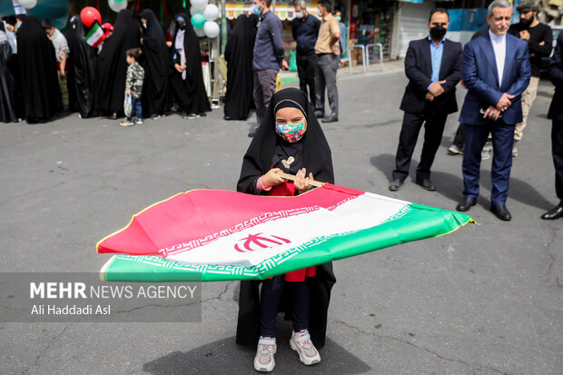 دختر بچه خردسالی با برافراشتن پرچم کشورمان در مراسم راهپیمایی روز جهانی قدس در تهران حضور دارد