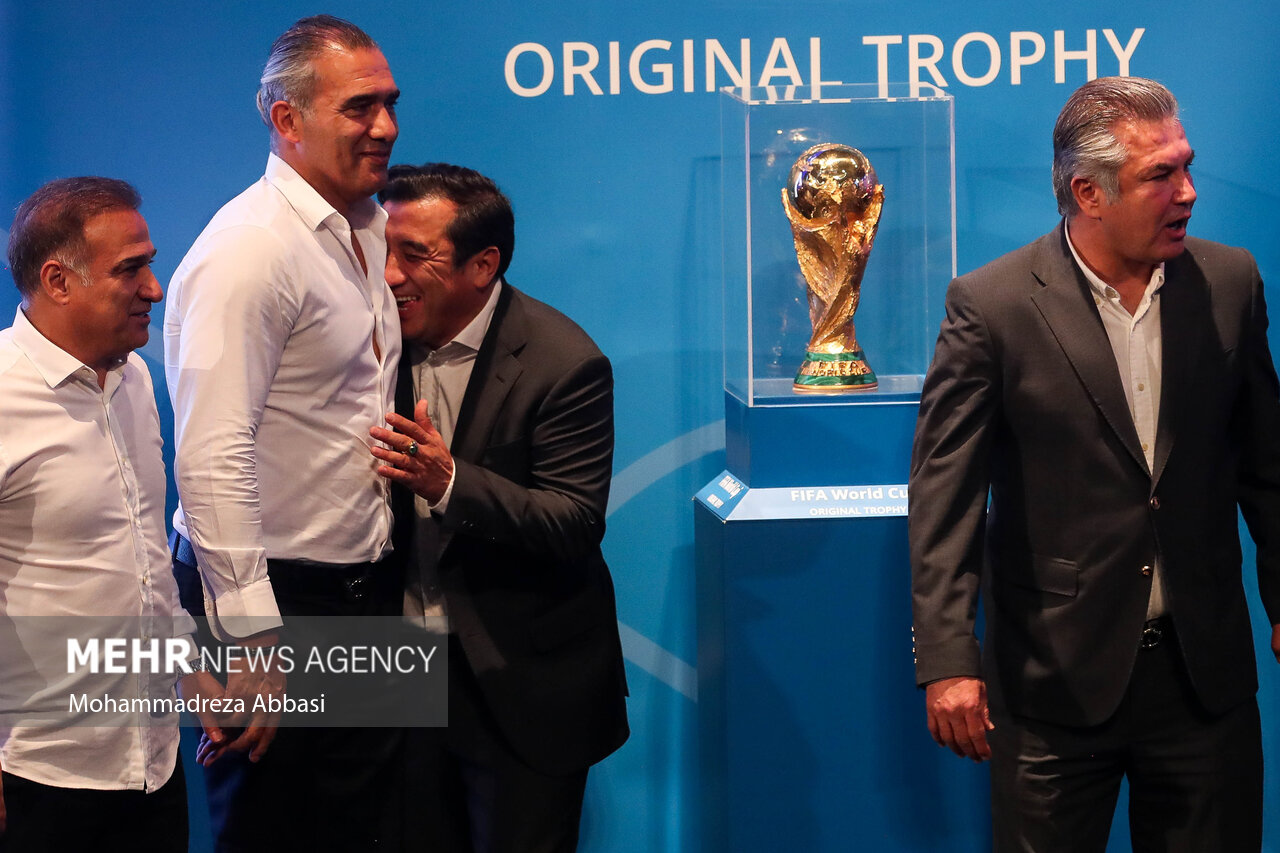 حمید استیلی پیشکسوت فوتبال ،خداد عزیزی ،احمدرضا عابدزاده و سیرویس دیمن محمدی در حال گرفتن عکس یادگاری با کاپ جام جهانی هستند