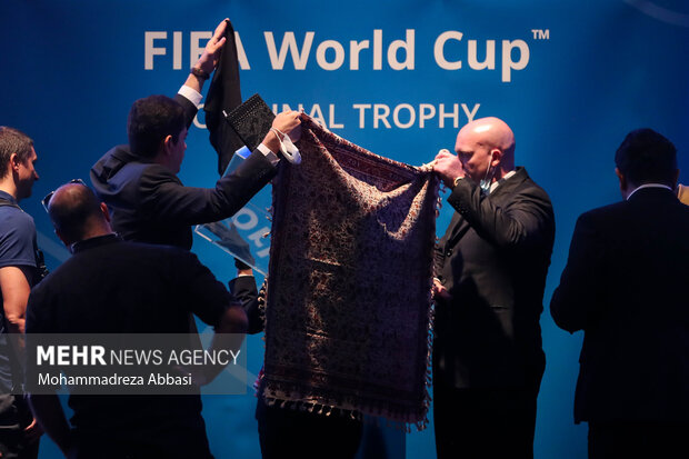 مسدولال فیفا در حال گذاشتن کاپ جام جهانی در جایگاه مخصوص خود در ابتدای مراسم رونمایی از کاپ جام جهانی در تهران هستند