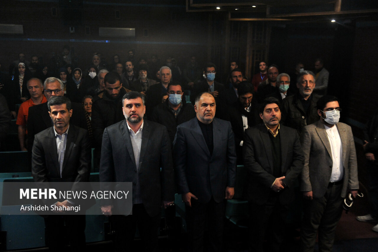 حاضرین در حال ادای احترام به سرود جمهوری اسلامی ایران در مراسم اختتامیه بیستمین جشنواره کتاب و رسانه هستند